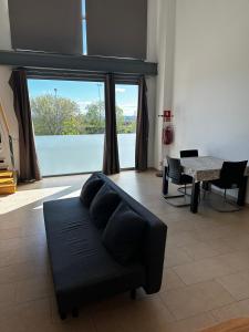 salon z czarną kanapą i stołem w obiekcie Loft luminoso Alcorcón M-40 Madrid w mieście Alcorcón