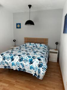 sypialnia z łóżkiem z niebiesko-białą kołdrą w obiekcie Loft luminoso Alcorcón M-40 Madrid w mieście Alcorcón