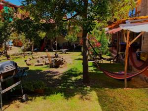 a hammock in a yard next to a house at Kamanti Hostel in Pisac
