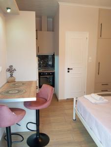 a room with a bed and a table and chairs at Angelos Apartment in Vathi, Ithaka