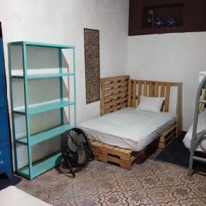 una camera con due letti e una libreria di Hostal Brunette Santein a Santa Ana