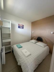a bedroom with a bed with two towels on it at T2 Bord de plage, résidence Bleu Marine 93 in Lacanau-Océan