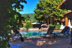 a pool with chairs and a table next to a house at Costa Bodrum City in Bodrum City