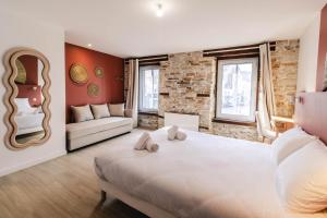 Un dormitorio con una gran cama blanca y un sofá. en L'Evasion Bretonne - Superbe T3 - Centre Ville - Balnéo, en Quimper