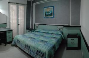 a bedroom with a bed and a desk and a television at Hotel San Nazario in Varazze