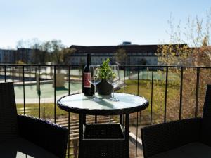 a table with two bottles of wine and a plant on a balcony at Studio 180 in Leipzig
