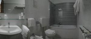 a bathroom with a sink and a toilet and a tub at Hotel San Nazario in Varazze +25 photos