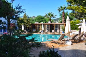 a swimming pool with lounge chairs and umbrellas at Costa Bodrum City in Bodrum City