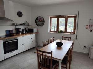 una cucina con tavolo, sedie, tavolo e tavolo e una cucina di Casa Barroca a Figueiró dos Vinhos Altre 22 foto