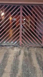 a red wooden gate with a door on a garage at Casa para alugar Agrishow 2025 in Ribeirão Preto
