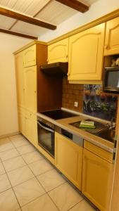 a kitchen with yellow cabinets and a stove top oven at Haus Sarah in Dornum +11 photos