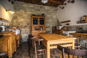 uma cozinha com uma mesa de madeira e cadeiras em Úrágya Vendégház em Mád