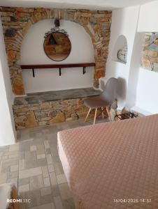 a bedroom with a stone wall and a bed at Lucas B Panorama in Sikinos