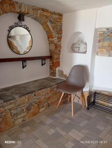 a chair in a room with a mirror and a clock at Lucas B Panorama in Sikinos +68 photos