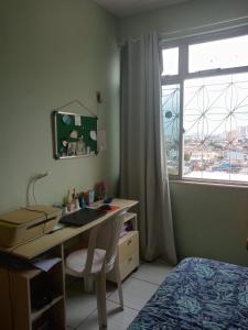 a bedroom with a desk and a bed and a window at Apartamento amplo, arejado e perto de tudinho COP 30 in Belém