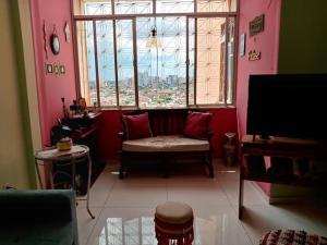 a living room with a bench and a large window at Apartamento amplo, arejado e perto de tudinho COP 30 in Belém