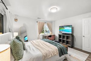 a bedroom with a bed and a flat screen tv at Entire Private 4-BR Home, Lux King Bed, Big Yard, Prime Area, Ranch Style, Available Now in La Mesa