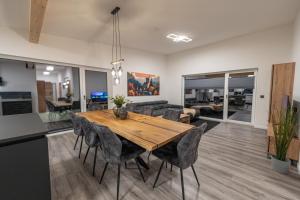 una cucina e una sala da pranzo con tavolo e sedie in legno di BPS Apartment #7 Luxury Penthouse - NEU - Deluxe - Modern a Horb am Neckar