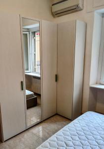 a bedroom with a closet with a mirror at OstiaByTheSeaCozyBedroom in Lido di Ostia