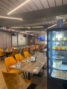 a restaurant with wooden tables and chairs and a counter at СПА Хотел Романтика in Sarnitsa