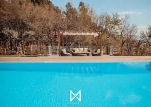 a gazebo with a couch and a pool at MyStay - Quinta dos Sobrais in Valença