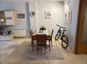 a dining room with a table and a bike at Surf&Snooze in Castelldefels
