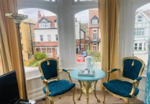 a room with two chairs and a table and a window at The Cobham Hotel in Southend-on-Sea