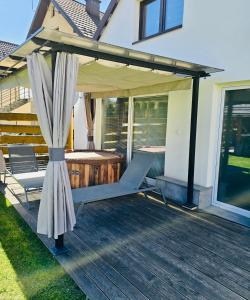 a patio with an umbrella and a deck at Loft House Rabka dom na wyłączność z jacuzzi SKI&SPA in Rabka +10 photos