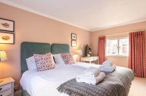 a bedroom with a bed with towels on it at Laundry Cottage in High Legh