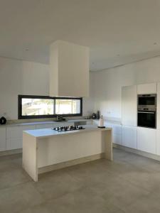 a large kitchen with white cabinets and a counter top at Villa spacieuse à Marrakech avec piscine privée_222 in Marrakech