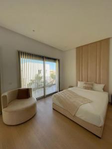 a bedroom with a large bed and a chair at Villa spacieuse à Marrakech avec piscine privée_222 in Marrakech
