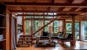 a living room with a staircase in a house at Kubla Khan - Chirripó Mountain Riverfront Retreat in Rivas
