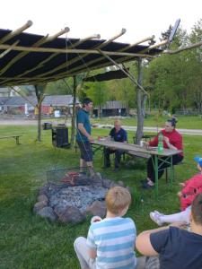 a group of people sitting around a picnic table at Altana letnia nr5 - Herbergerówka Agroturystyka na wsi in Stosrow +4 photos
