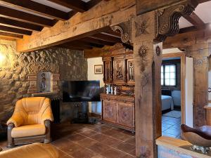 a living room with a tv and a couch and a chair at Apartamentos Villa Julieta in Ruente