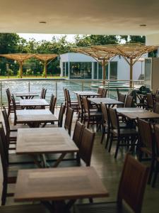 an empty restaurant with wooden tables and chairs at Pipa Privilege Ocean Oficial in Pipa