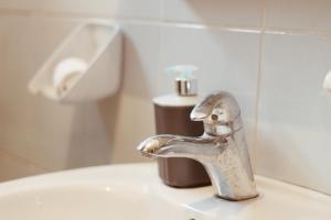 a bathroom sink with a faucet on a toilet at Apartment Baščaršija-parking i klima in Sarajevo +20 photos