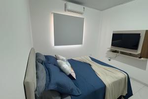 a bedroom with a bed and a flat screen tv at AP 6 C/Garagem>Ar>Wifi>Cozinha>Tv Disney+>Pet free in Ji-Paraná