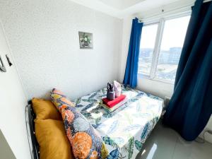 a bedroom with a bed with blue curtains and a window at Sea Residences Navigators in Manila