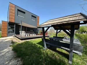a house with a gazebo in front of it at Swan Apartman in Sándorfalva