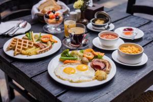 a wooden table with plates of breakfast food on it at Hotel Marshyangdi in Kathmandu