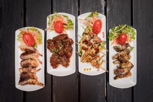 three plates of food with meat and vegetables on a table at Hotel Marshyangdi in Kathmandu