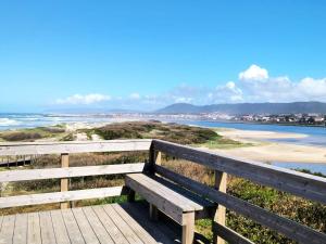 a wooden bench sitting on a boardwalk near the beach at Apartamento Sol e Mar in Fão