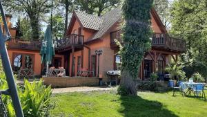 an orange house with an umbrella and a yard at FeWo Cuba in Neue Scheune