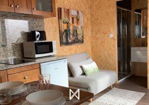 a living room with a couch and a microwave at MyStay - Bungalow in Quinta dos Sobrais in Valença