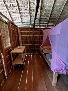 a room with a bed and a table in it at Batanta Panorama Homestay in Dayang