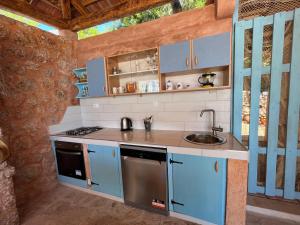 a kitchen with blue cabinets and a sink at Kolonjicha Dvori in Ivan Dolac