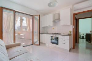 a kitchen with white cabinets and a stove top oven at Casa Suite Himalaya Estate in Sardegna Vicino al Mare e Aeroporto Wi-Fi & Parcheggio in Selargius