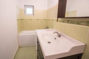 a bathroom with a white sink and a tub at Spacious apartment Near National Arena, parks in Bucharest