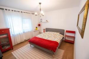 a bedroom with a bed with a red blanket at Spacious apartment Near National Arena, parks in Bucharest