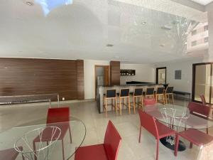 a dining room and kitchen with red chairs and a table at Via Brisa Apartment in Brasília